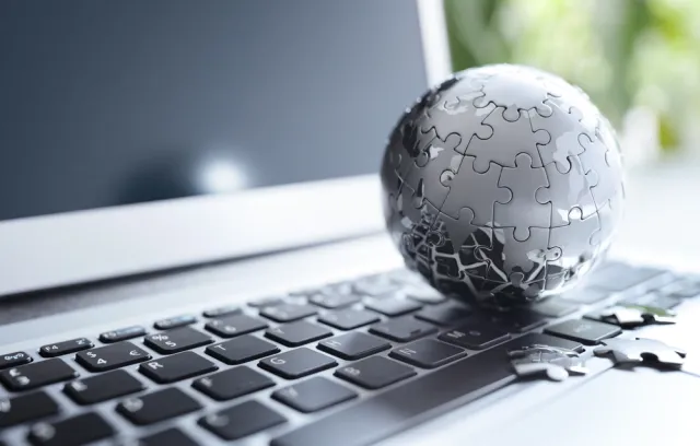 Foto de una mundo armado con piezas de rompecabezas color gris sobre un teclado