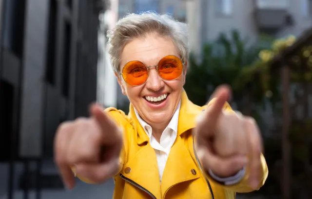 foto de una señora señazando a la cámara fotográfica