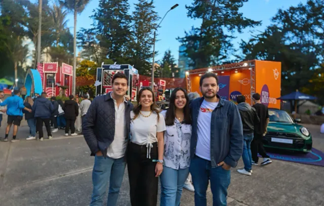 Foto de cuatro personas con un fondo de festival