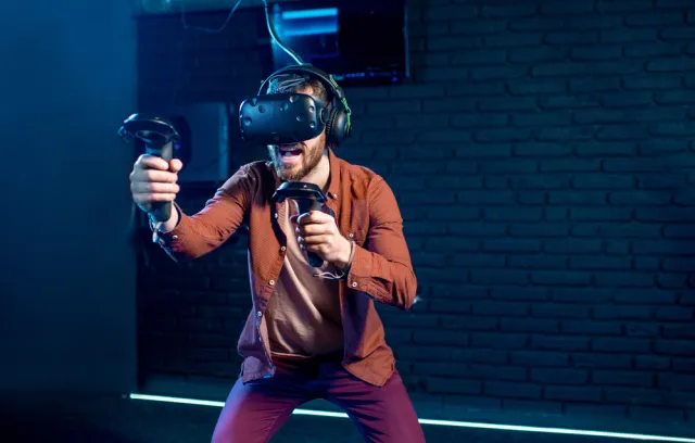 Hombre jugando con gafas de realidad aumentada con un fondo azul