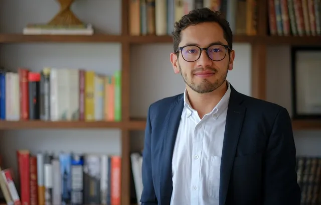 Foto de un hombre con camisa blanca y traje azul mirando a la cámara