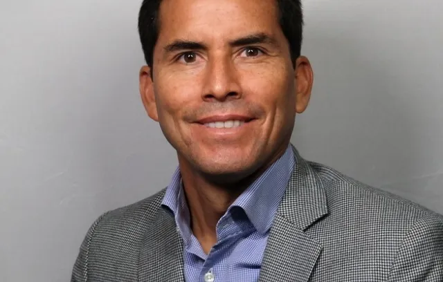 Foto de un hombre sonriendo a la cámara