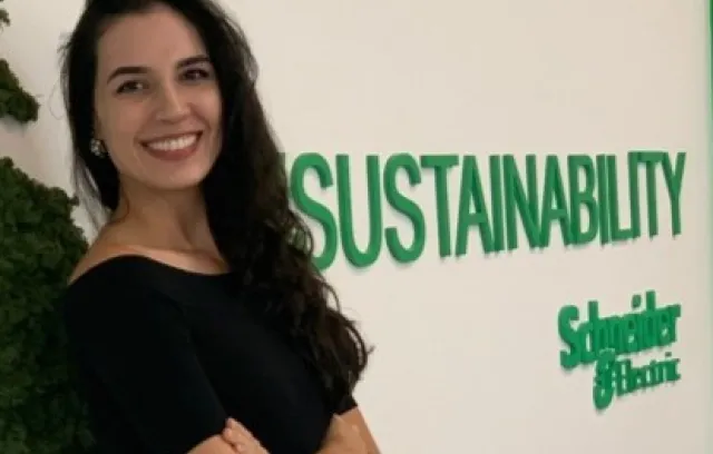 Foto de una mujer posando al frente de un logo de Schneider