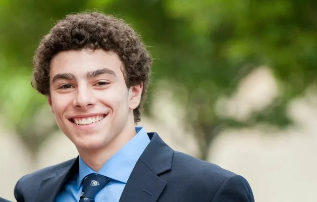 Foto de un jóven sonriendo a la cámara