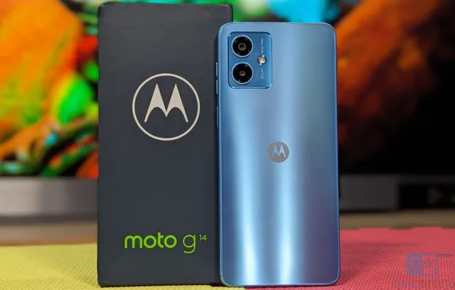Foto de motorola, celular azul claro con una caja nega de fondo