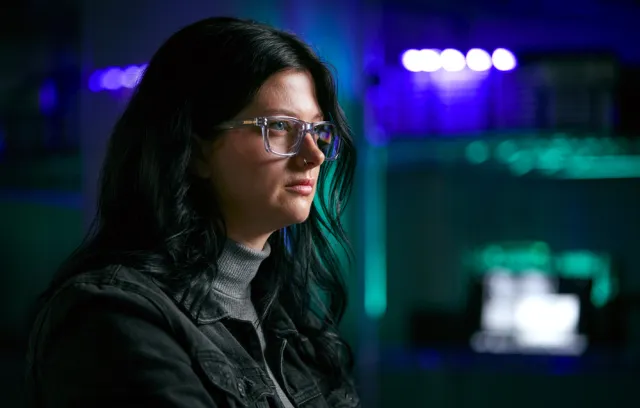 Mujer con gafas de perfil, pelo negro, viendo una pantalla