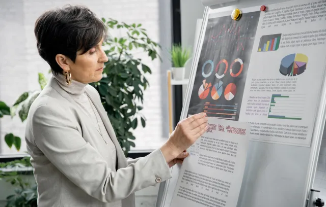 Mujer de perfil mirando gráficas en papel