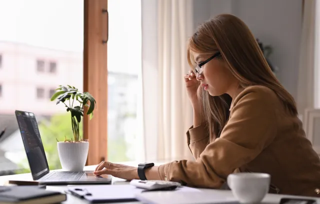 Mujer mirando el computador portátil en una sala
