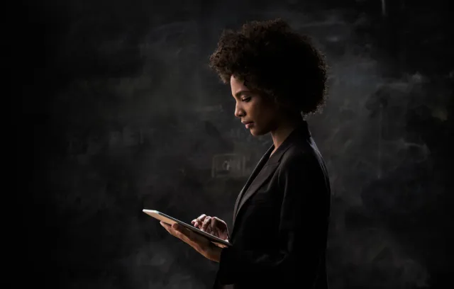 Mujer mirando computador con fondo negro
