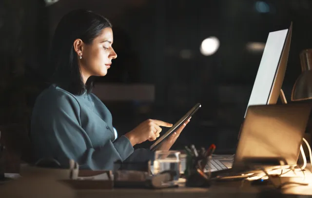 Mujer mirando una tablet en su escritorio