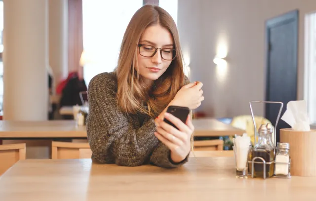 Mujer rubia paga por un teléfono celular