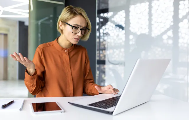 Mujer quejandose al frente de un computador