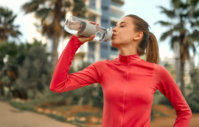 Mujer tomando agua de un termo