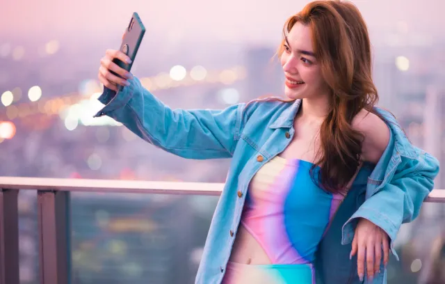 Mujer tomándose una fotografía con un fondo de ciudad