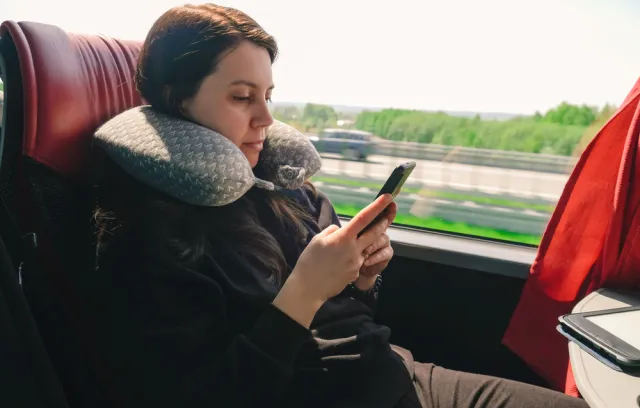 Una mujer viaja en una flota mientras revisa su celular