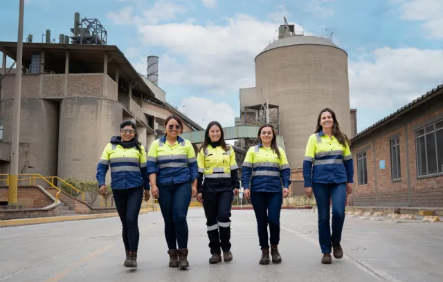 Mujeres Holcim con un fondo de fábrica