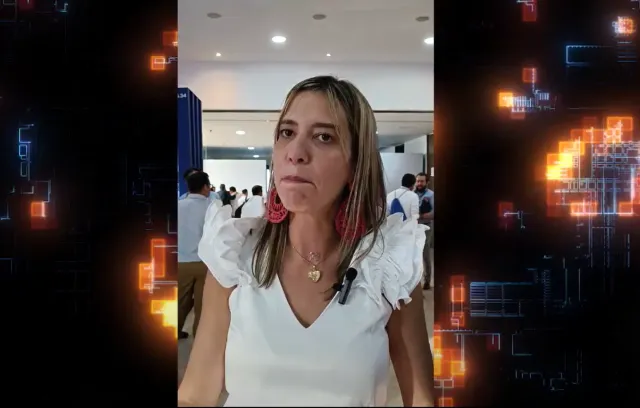 Fotografía de una mujer mona con blusa blanca hablando a la cámara