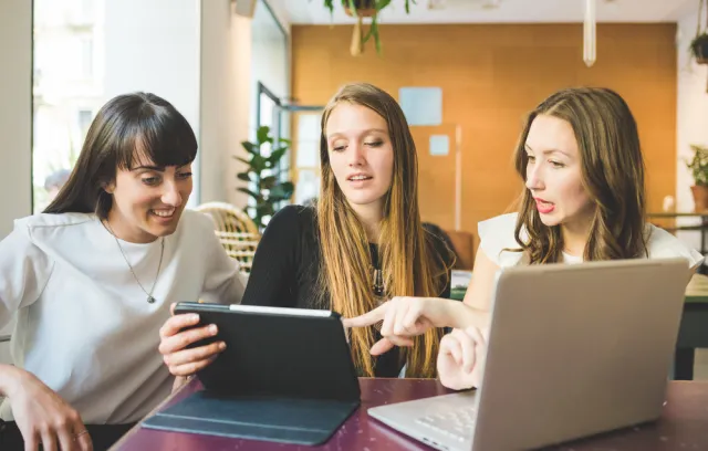 Mujeres reunidas en una mesa compartiendo ideas