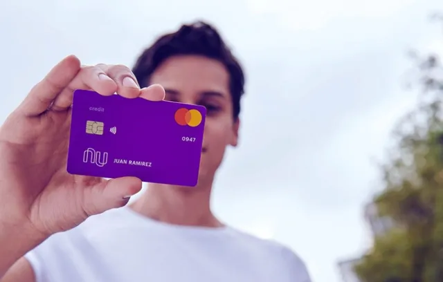 Foto de una persona joven con una carta de crédito en la mano