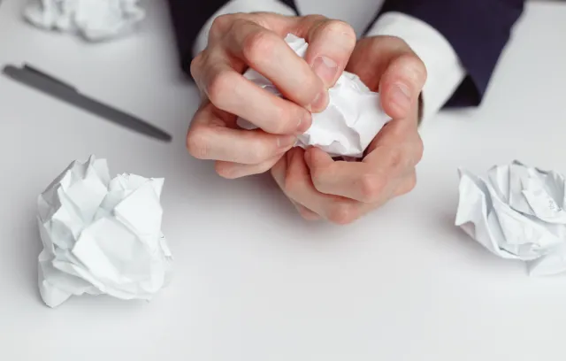 Una persona arrugando un papel