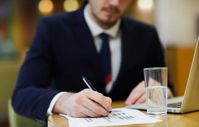 hombre escribiendo sobre un papel