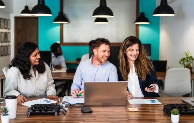 Personas en una oficina sonriendo frente a una mesa