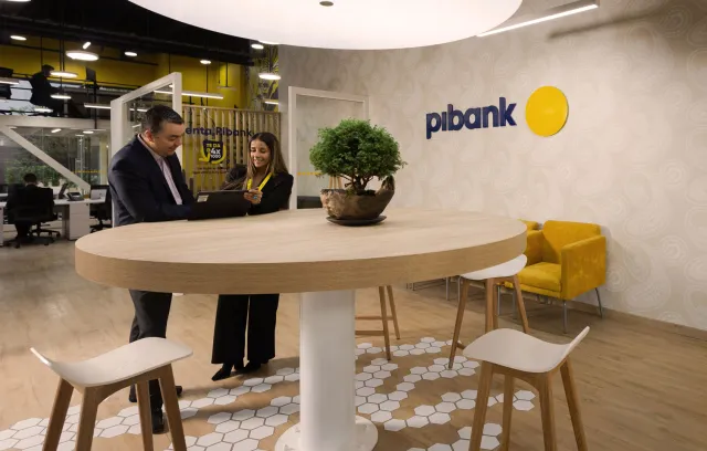 dos personas hablando en una oficina de Pibank