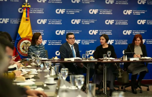 Reunión de cuatro personas sentadas en una mesa conversando