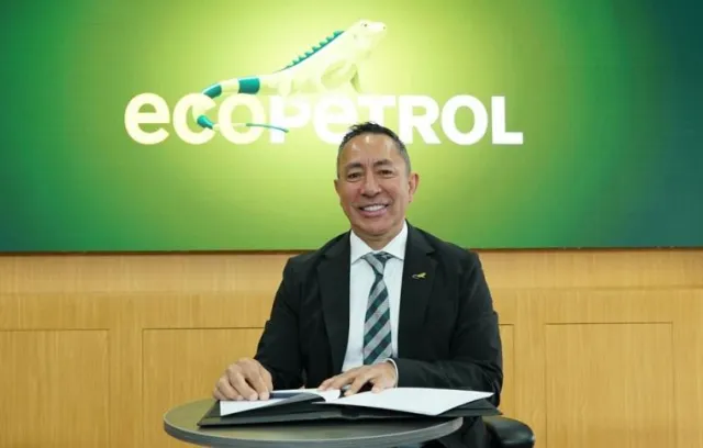 Señor con traje sonriendo a la cámara con fondo verde
