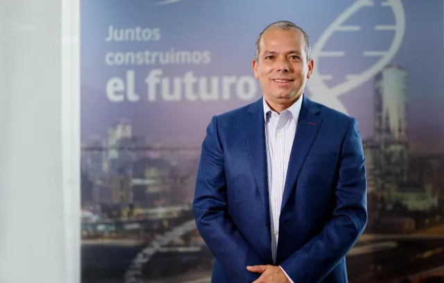 Hombre blanco con camiseta y blazer azul mirando a la cámara bla