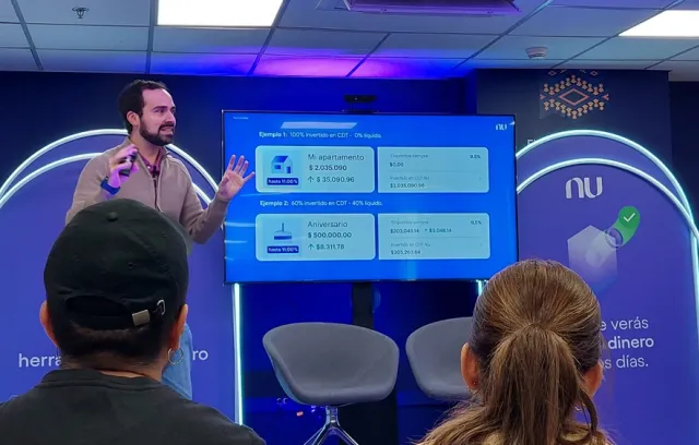 Foto de un hombre mirando a la cámara frente a un panel