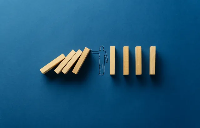 Silueta de una persona frenando frenando unos palos de madera