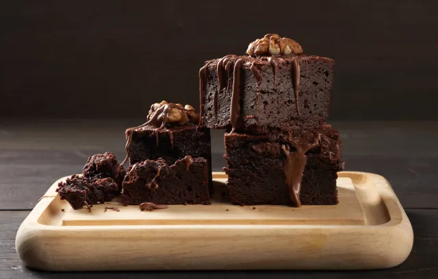 Torta de chocolate sobre una tabla de madera con un fondo negro