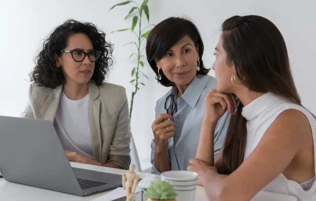 Tres mujeres hablando mientras se encuentran sentadas