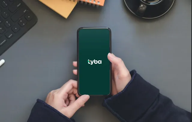 foto de una persona tomando un celular donde aparece la palabra tyba