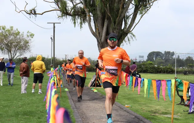 Foto de una persona corriendo en una maratón con una camiseta naranja