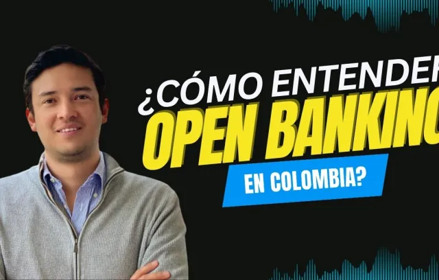 Hombre sonriendo a la cámara con letreros al costado derecho