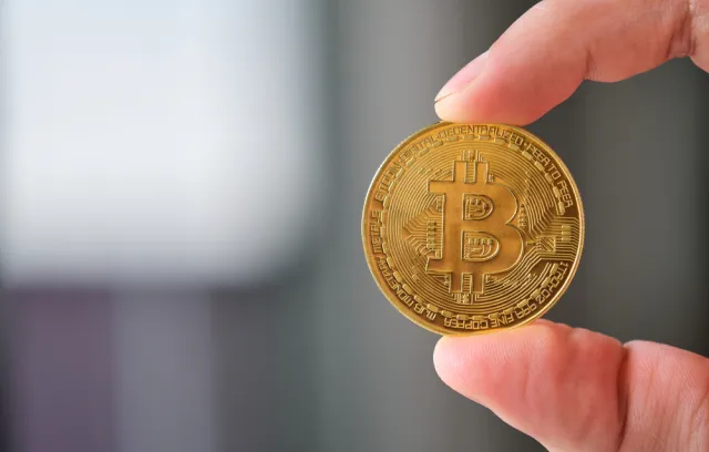 dos dedos sosteniendo una moneda