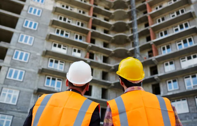 foto de dos arquitectos de espalda mirando  un edificio en construcción