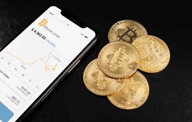 foto de un celular y unas monedas cripto