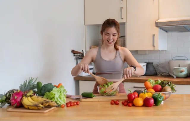 foto de una mujer preparando una receta con varias frutas al rededor