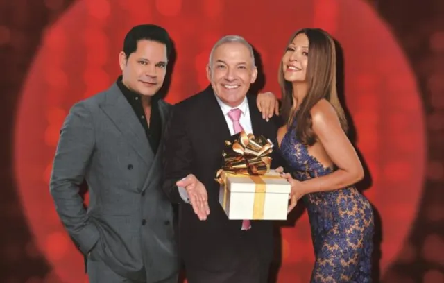 foto de una mujer y dos hombres posando con un regalo en sus manos