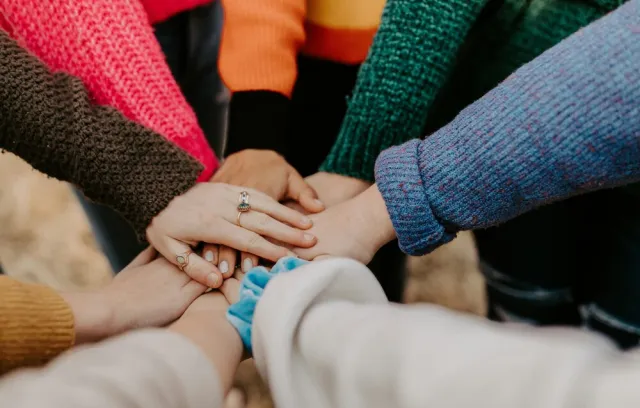 foto de varias personas poniendo su mano en el centro