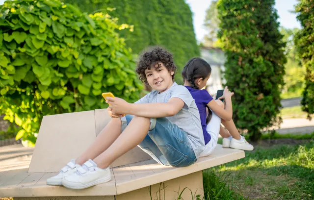fotografía de dos niños con un celular en sus manos