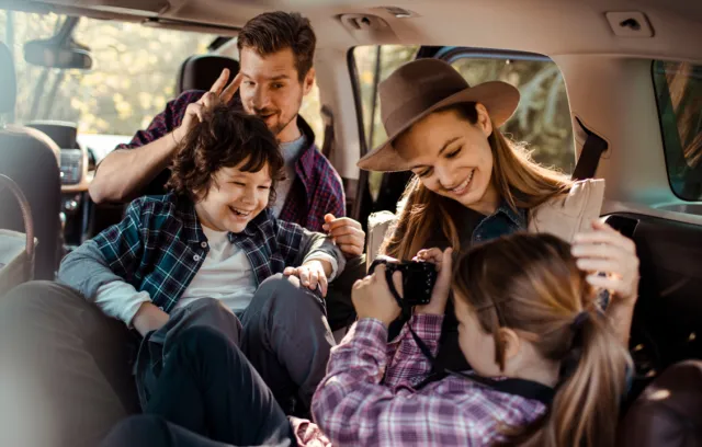 familia en un carro tomando fotografías