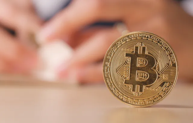 moneda cipto sobre una mesa con dos manos de fondo