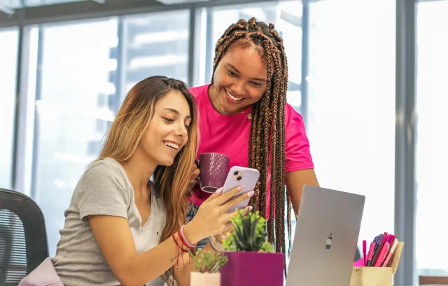 dos mujeres viendo un celular
