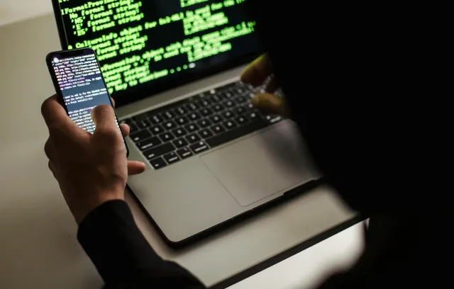 persona con su laptop y un celular