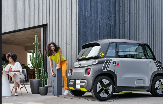 dos personas cargando tu carro electrico