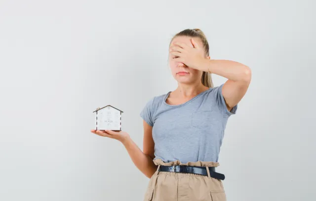 fotografía de una mujer sosteniendo un reloj y tapandose el rostro